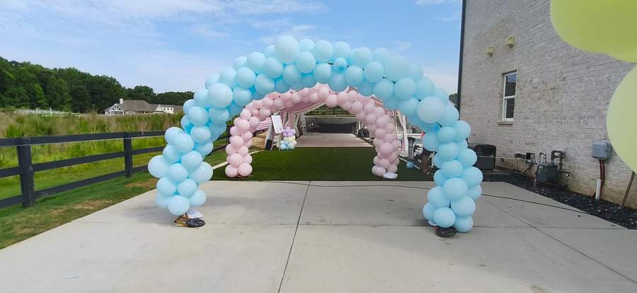 Blue and pink balloon arch at the entrance of a home celebration