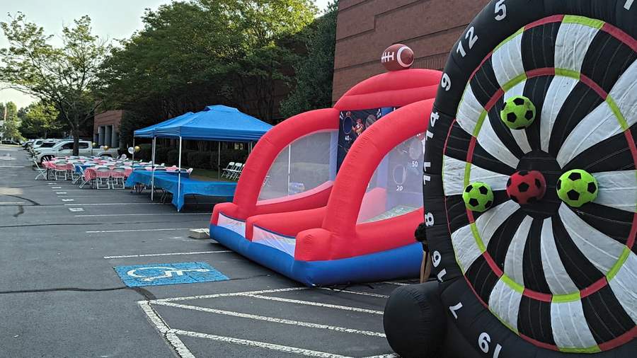 Large outdoor event with tables and inflatable games